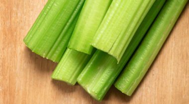 pile of cut celery sticks on wood cutting board
