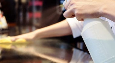 hands with spray bottle washing counter