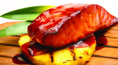 glazed salmon fillet, cooked, resting on pineapple ring