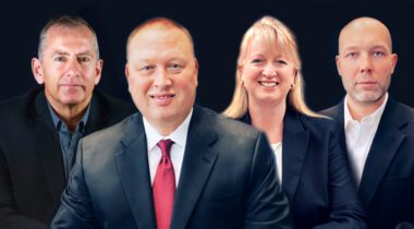 4 caucasians in suits smiling